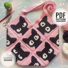 a crocheted bag with black and white cats on it next to knitting supplies