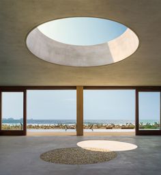 an empty room with large windows overlooking the beach