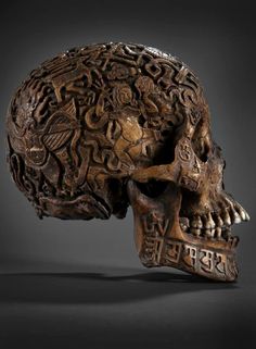 an intricately carved human skull is displayed on a black background with the word love spelled below it