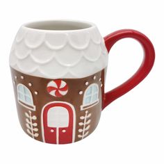 a red and white mug with a gingerbread house on it