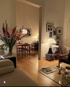 a living room filled with furniture next to a dining room table and chairs on top of a hard wood floor