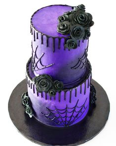 two tiered cake decorated with purple icing and black roses