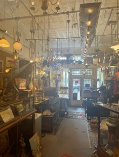 the inside of a store with lots of items hanging from it's ceiling and chandeliers