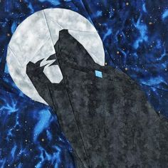 a bat quilted on top of a blue background with the moon in the sky