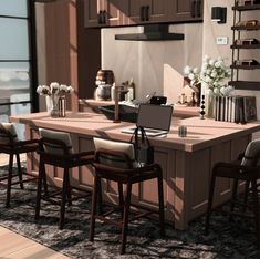 a computer desk sitting in the middle of a kitchen next to some chairs and cabinets