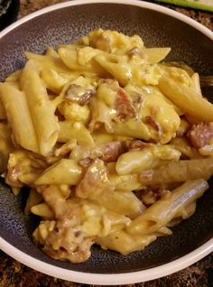 a bowl filled with pasta and meat covered in sauce