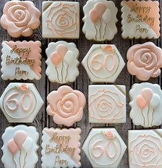 decorated birthday cookies with pink icing and rose decorations on a wooden surface, for a 60th birthday party