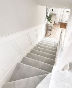 the stairs lead up to the kitchen and dining room in this house with white walls