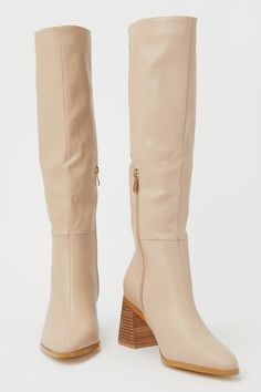 The best way to style the Billini Holden Biscuit Beige Pointed-Toe Knee-High Boots is with your favorite fall dress or a flirty mini skirt with tights! Faux pebbled leather shapes these super chic boots that feature a classy pointed-toe upper that rises to a 15.5"" knee-high shaft with a 10"" zipper at the instep and a 15"" circumference. A wood-look stacked block heel completes the trendy look! Available in whole sizes only. 3" wood-look stacked block heel. Lightly cushioned insole. Rubber sole Cream Knee-high Heeled Boots For Fall, Knee-length Heeled Boots For Fall, Elegant Tall Boots For Fall, Chic Knee-high Boots With Stacked Heel For Fall, Chic Cream Knee-high Boots, Chic Cream Fitted Knee-high Boots, Fitted Cream Knee-high Boots For Fall, Chic Fitted Cream Knee-high Boots, Elegant Beige Knee-high Boots For Work