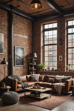 an industrial living room with brick walls and exposed ceilings, leather couches, coffee table, rugs and large windows