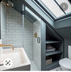 an attic bathroom with skylights and white tile