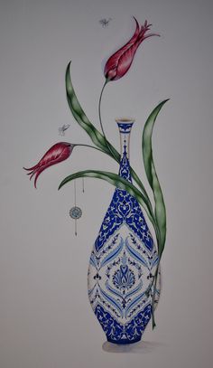 a blue and white vase with red flowers in it on a white wall next to a plant