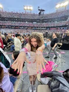 a woman with her hands in the air at a concert