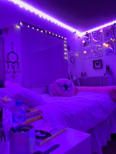 a bedroom with purple lighting and pictures on the wall