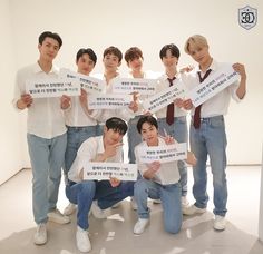 a group of young men holding up signs in front of their faces with words written on them