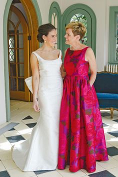 two women standing next to each other in formal wear, one wearing a red and pink dress