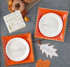 two plates with the words thank you written on them next to fall leaves and a donut