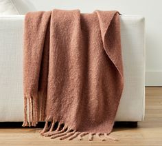 a blanket on a white couch with wood flooring