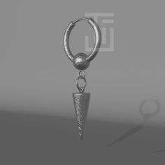 a metal object is hanging from a hook on a gray background with the shadow of an object in the foreground