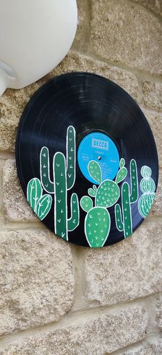 a record with cactus decals on the side of a wall next to a cup