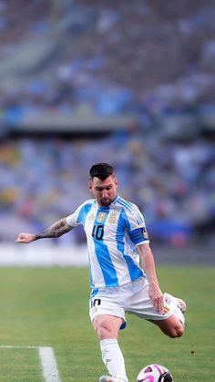 a man kicking a soccer ball on top of a field