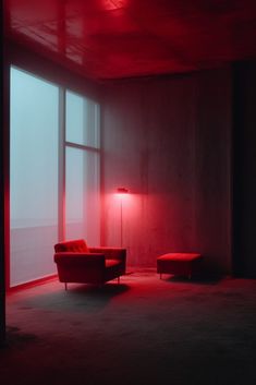 an empty room with a red light coming from the window and a chair in the corner