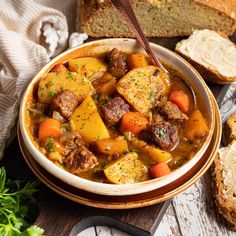 a bowl of stew with bread on the side