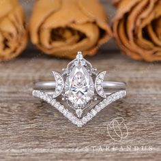 an engagement ring with a pear shaped center surrounded by diamonds