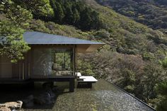 a house on the side of a mountain with trees around it