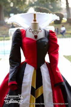 a woman wearing a dress made out of black and white material with red trims