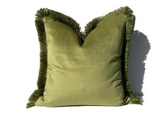 a green pillow with ruffled edges on a white background