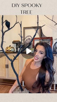 a woman sitting on a chair in front of a tree with black birds perched on it