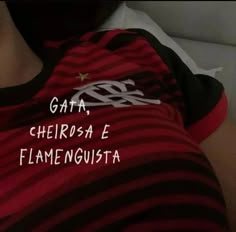 a person wearing a red and black striped shirt with white writing on the chest that says gata, cherosa e flamencousta