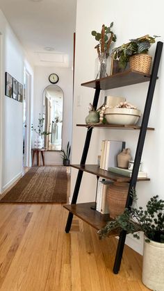 a ladder shelf with books and plants on it