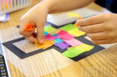 a child is making a craft with colored construction paper