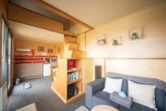 a living room filled with furniture and bookshelves next to a kitchen counter top