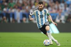 a soccer player is running with the ball in his hand while people watch from the stands