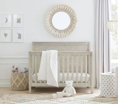 a baby's room with a crib, teddy bear and pictures on the wall