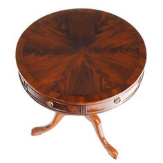 a small round wooden table with two drawers