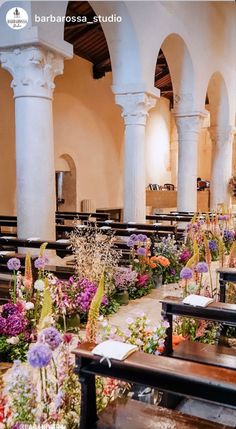 the interior of a church with rows of pews and flowers on the ground in front of them