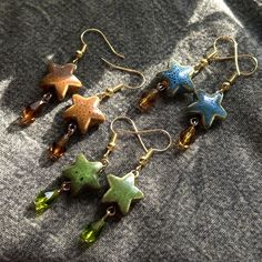 pretty ceramic star earrings with dangly glass beads, on golden plated earring hooks <3 star beads are ~.5 inches, so relatively small with a dainty look! perfect for anyone with an earthy, whimsical, or hippie aesthetic :) each pair has slight differences as all ceramic beads are different! available with rhodium hooks upon request, please message me first! matching bracelets can be found on my shop page in the bracelet section :) lead / nickel free Space Themed Earrings, Earth Tone Earrings, Thing To Get For Christmas List, Ceramic Bead Earrings, Asthetic Earings, Minecraft Earrings, Green Vibes Aesthetic, Home Made Earrings