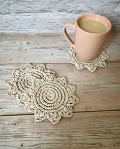 a cup of coffee sitting on top of a wooden table next to a doily