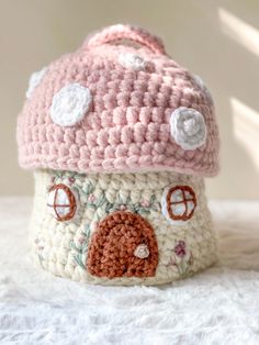 a crocheted mushroom hat on top of a white blanket