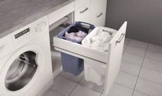 a washer and dryer in a room with tile flooring, white cabinets and gray counter tops