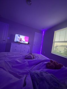 a bedroom with purple lighting and a flat screen tv