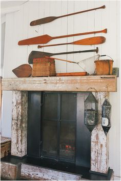 an old fireplace mantel with canoes hanging from it's sides and baskets on top