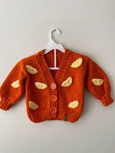 an orange knitted cardigan with lemons on it