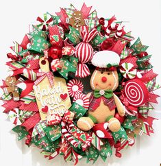 a christmas wreath with a teddy bear, candy canes and candies on it