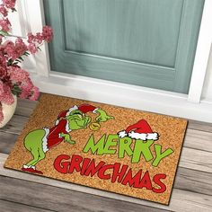 a door mat with the words merry grinmas on it next to a potted plant