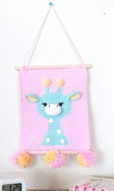 a pink and blue wall hanging with a giraffe on it